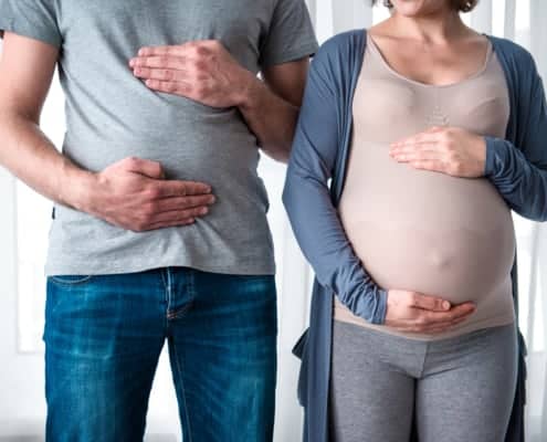 Couvade syndrome, Mom and dad hold belly