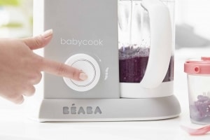 Hand pressing puree button on BEABA Babycook Cloud