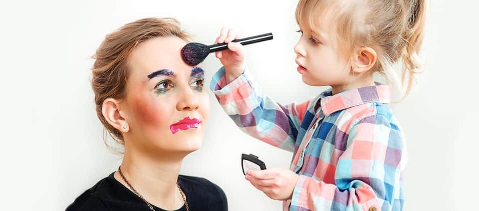 Baby putting on make up on mom