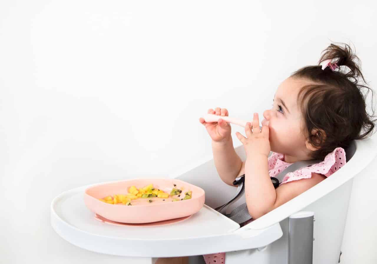 Toddler Smiling in High Chair with Meal Set in Use