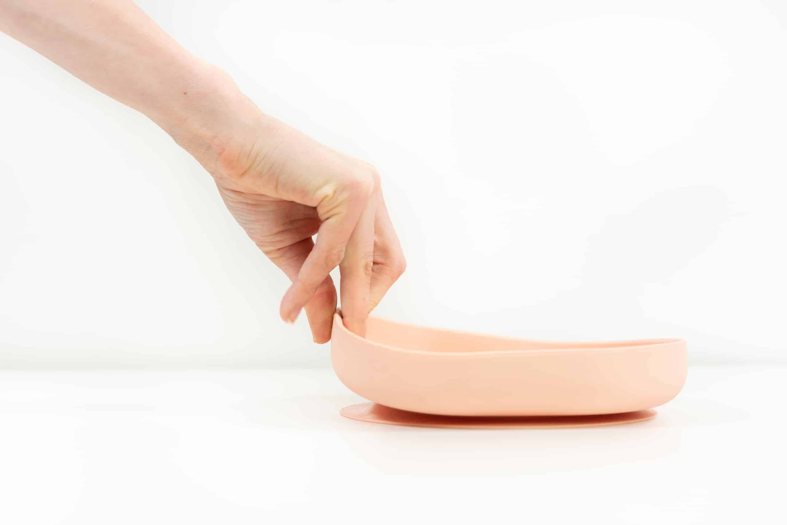 Hand tugging on silicone suction plate rose