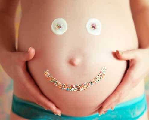 pregnant belly with smiley face made of icing