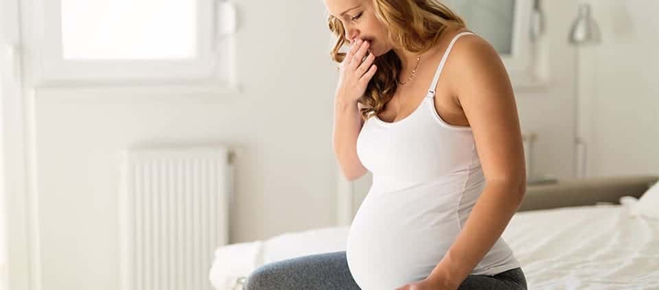 Pregnant woman with hand over her mouth