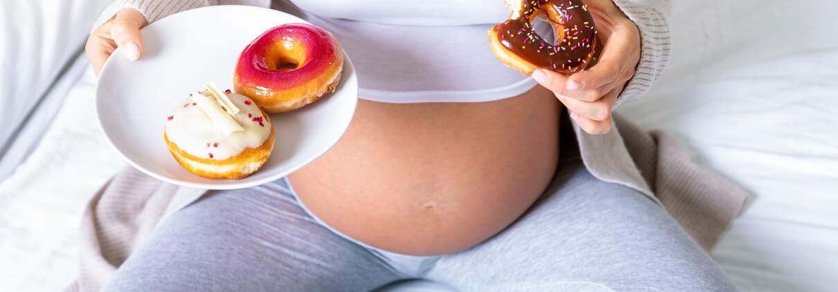 Pregnant woman eating donut