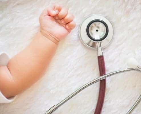 Baby hand next to stethoscope