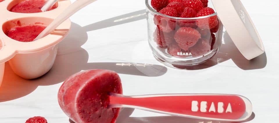 Berry and Breast Milk Popsicles Laying on Kitchen Background with Spoon