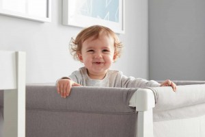 Baby smiling while in BEABA by Shnuggle Air Cot Conversion Kit