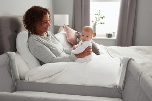 Mom Holding Baby In Bed