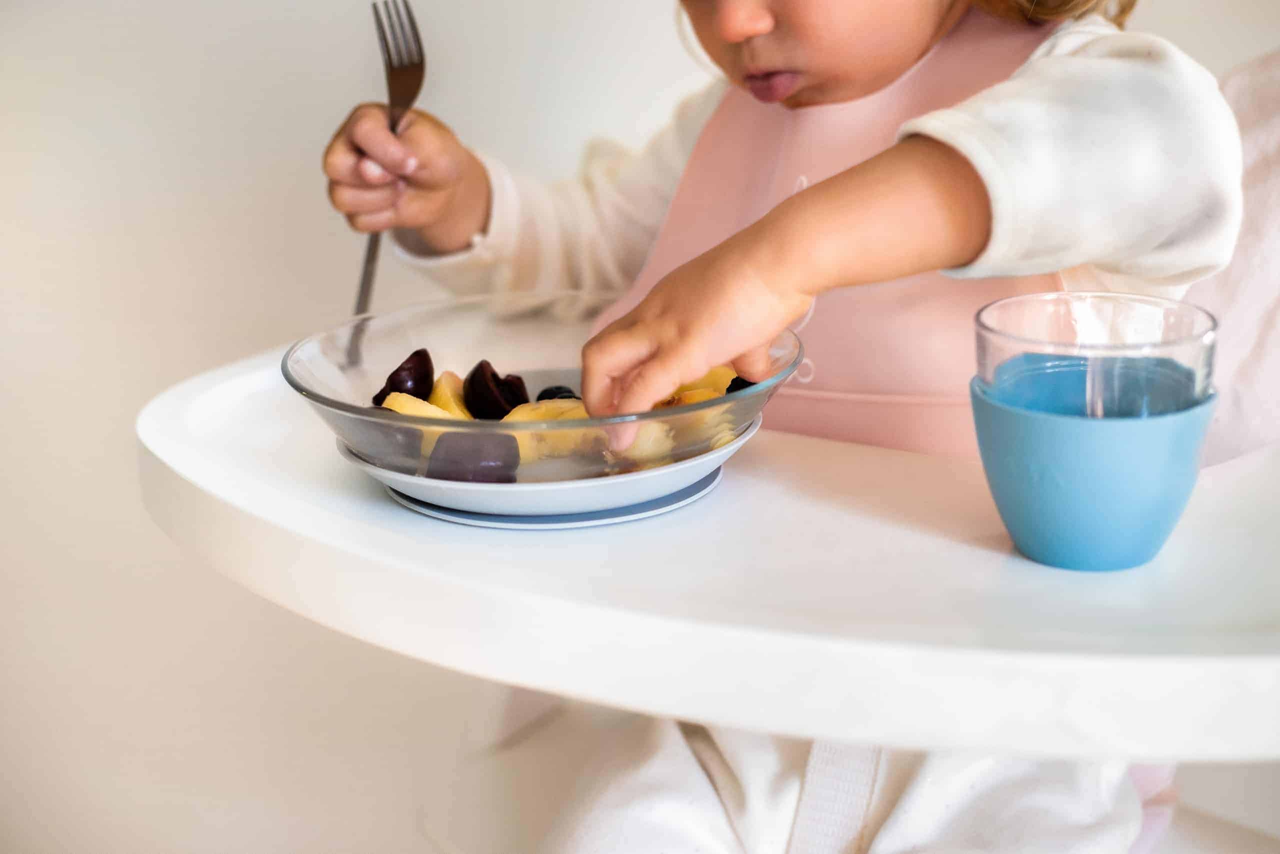 toddler eating from glass meal set