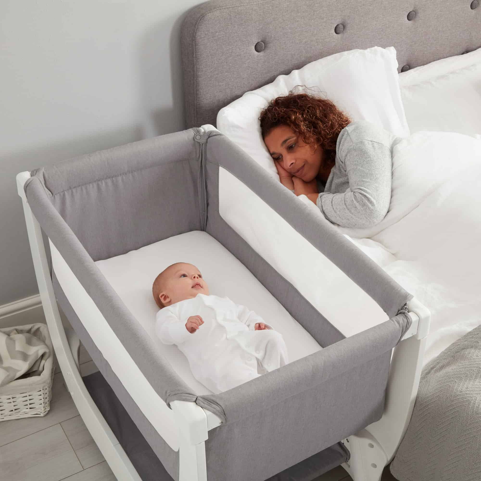 mom sleeping next to baby in bedside bassinet