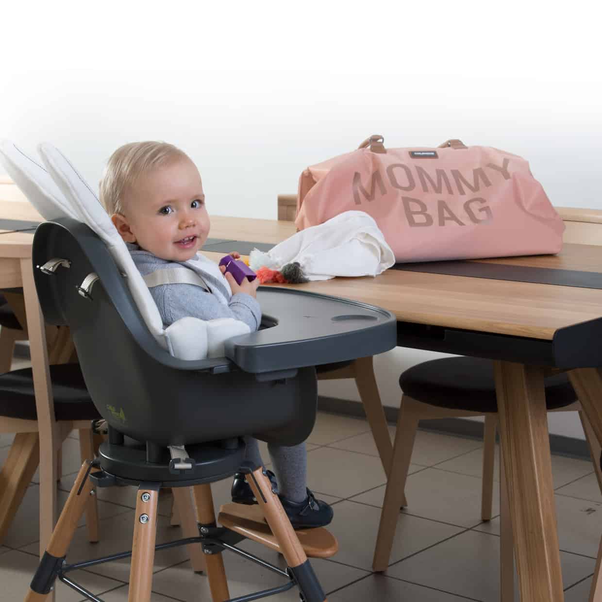 Baby sitting in highchair with Childhome Mommy Bag Pink/Copper