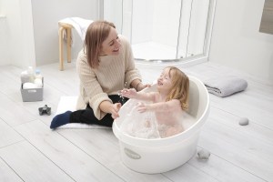 Toddler splashing in Shnuggle Toddler Bath