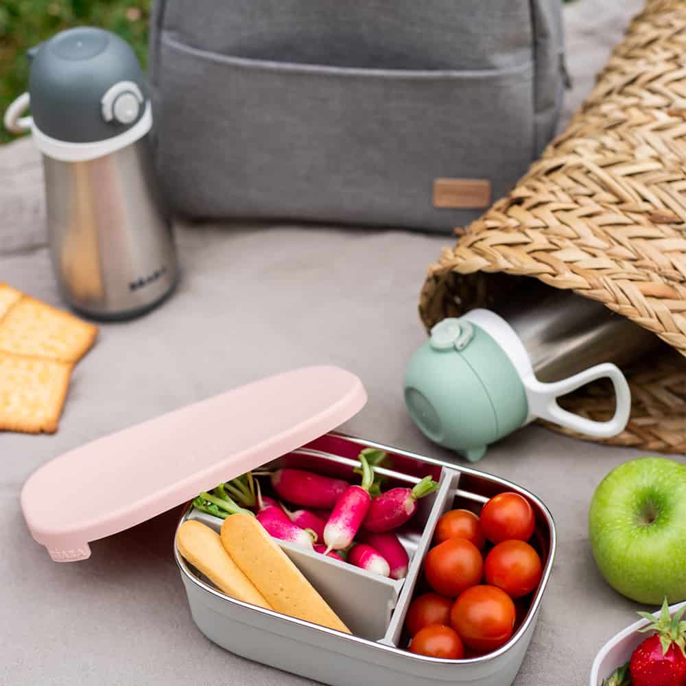 stainless steel lunch box rose on picnic blanket filled with radish tomatoes and cheese