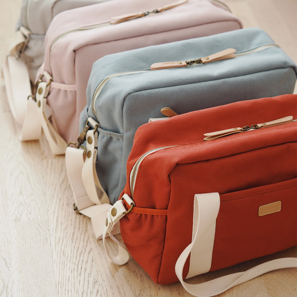 paris diaper bag collection in colors brick, sage, dusty pink and pearl grey